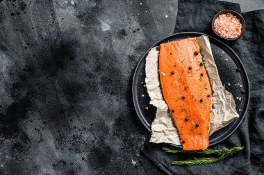 Taze somon fileto, tuz, bitki ve baharatlı. Siyah arka plan. Üst Manzara. Boşluğu kopyala.