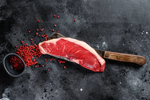 Raw marbled beef steak. black Angus meat. Black background. Top view. Copy space.