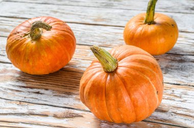 Sonbahar Balkabağı Şükran Günü Geçmişi, ahşap masadaki turuncu balkabakları. Beyaz ahşap arka plan. Üst görünüm.