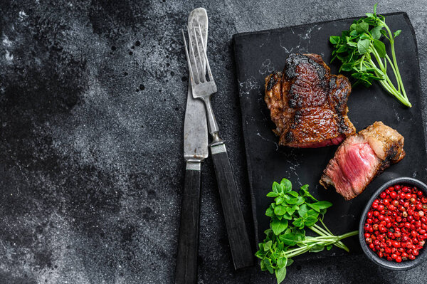 Grilled rump marble Beef steak. Black background. Top view. Copy space.