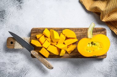 Kesme tahtasında dilimlenmiş çiğ portakal kabağı. Beyaz arka plan. Üst görünüm.