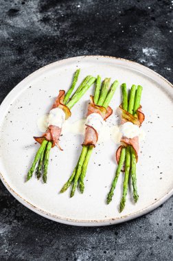 Parma jambonlu yeşil kuşkonmaz. Siyah arka plan. Üst görünüm.