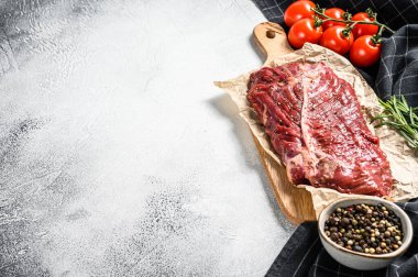 Kesme tahtasındaki üst bıçak bifteği, çiğ et, mermer et. Gri arka plan. Üst Manzara. Boşluğu kopyala.