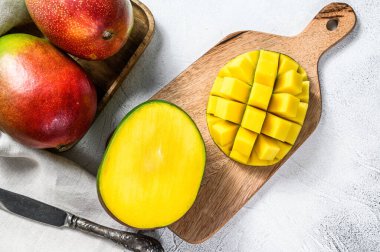 Kesme tahtasında kesilmiş mango meyveleri. Gri arka plan. Üst görünüm.