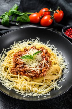 Domates soslu İtalyan spagettisi, peynirli parmesan ve fesleğen. Siyah arka plan. Üst görünüm.