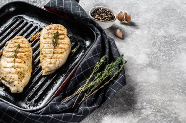 Tavada ızgara tavuk göğsü kekik ve sarımsaklı. gri arka plan. Üst Manzara. Boşluğu kopyala.