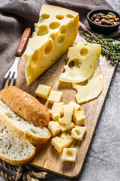 Yellow cheese with holes, dairy products. Gray background. Top view.