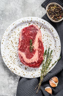 Mermer biftekli biftek. Çiğ pirzola, pirzola. gri arka plan. en üstteki görünüm.