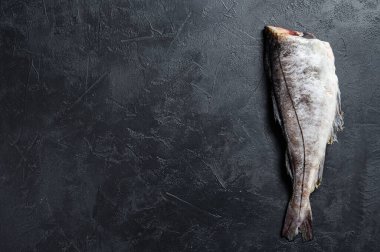 Başsız çiğ mezgit balığı. Siyah arka plan. Üst Manzara. Boşluğu kopyala.