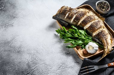 Kesme tahtasında bütün balık mezgit balığı pişirdim. Gri arka plan. Üst Manzara. Boşluğu kopyala.