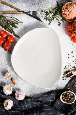 Taze çiğ sebze ve sebzelerin ortasında beyaz boş bir tabak. Sağlıklı, temiz yemek, vejetaryen, diyet yemek konsepti. Beyaz arka plan. Üst Manzara. Boşluğu kopyala.