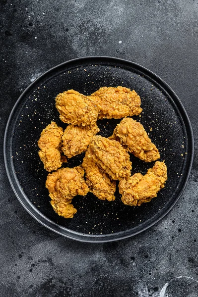 homemade baked crispy chicken wings. Black background. Top view.