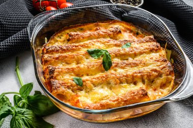Domates soslu ve peynirli etli cannelloni. İtalyan mutfağı. Gri arka plan. en üstteki görünüm.