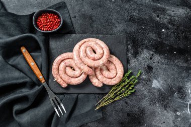 Çiğ domuz sosisi. Siyah arka plan. Üst görünüm