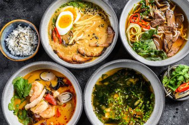 Geleneksel Asya çorbaları. Miso, Ramen, Tom Yam, Pho Bo. Siyah arka plan. Üst görünüm.