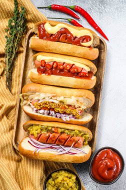 Sosisli sandviçler ve çeşitli malzemeler. Domuz ve sığır etli sosisli nefis sosisler. Beyaz arka plan. Üst görünüm.