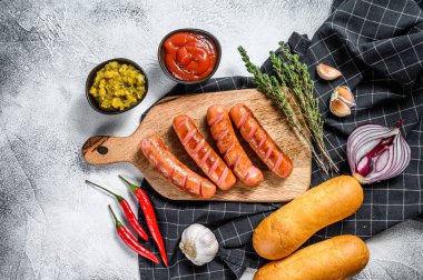 Farklı ev yapımı sosisli sandviçler, kızarmış soğan, biber, domates, ketçap, salatalık ve sosis. Beyaz arka plan. Üst görünüm.