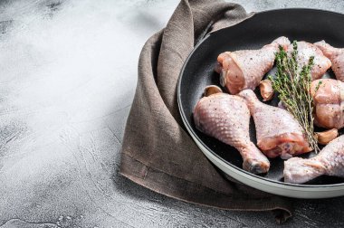 Çiğ organik tavuk budu, baharat ve tavada pişirmeye hazır sarımsak. Beyaz arka plan. Üst Manzara. Boşluğu kopyala.