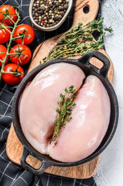 Tavada çiğ tavuk göğsü fileto ve baharat. Beyaz arka plan. Üst görünüm.