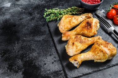 Baharatlı tavuk budu, baharatlı bacaklar ve otlar. Siyah arka plan. Üst Manzara. Boşluğu kopyala.