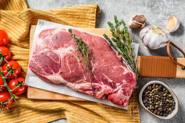 Raw marble pork steak on a wooden chopping Board. Organic meat. Gray background. Top view.