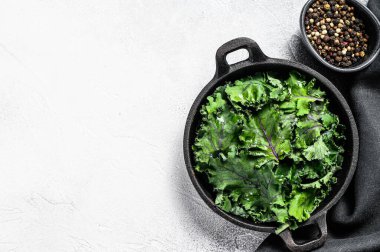 Tavada çiğ yeşil Kale salatası. Organik vejetaryen yemekleri. Beyaz arka plan. Üst Manzara. Boşluğu kopyala.