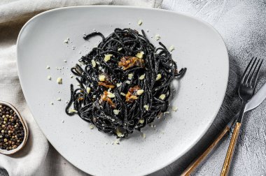 Krema soslu ton balıklı siyah spagetti makarna. Gri arka plan. Üst görünüm.