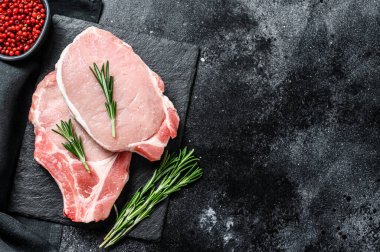 Çiğ domuz filetosu bifteği. Organik et. Siyah arka plan. Üst Manzara. Boşluğu kopyala