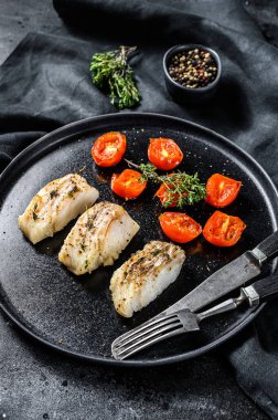 Bir porsiyon ızgara, fırında pollock veya kömür balığı filetosu. Siyah arka plan. Üst görünüm.