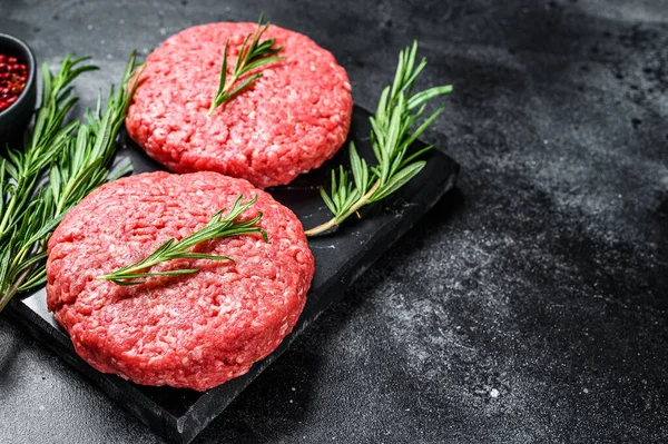 Patty of minced meat for burger. Black background. Top view. Copy space.