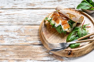 Yumuşak krem peynirli baget sandviç, armut ve pazı. Beyaz arka plan. Üst Manzara. Boşluğu kopyala.