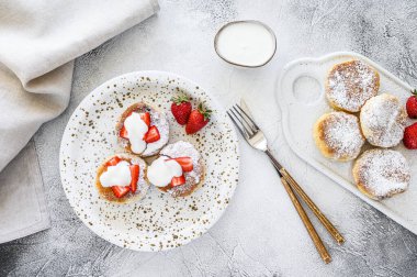 Süzme peynirli krep, şurup, çilekli peynirli börek. Gri arka plan. Üst görünüm.