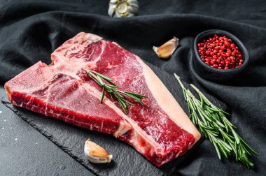 Biftek. Organik çiğ Tbon eti. Siyah arka plan. Üst görünüm.