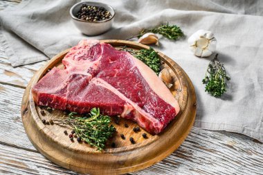 Çiğ et, biftek, baharat, sarımsak ve biberiye. Organik kemik eti. Beyaz arka plan. Üst görünüm.