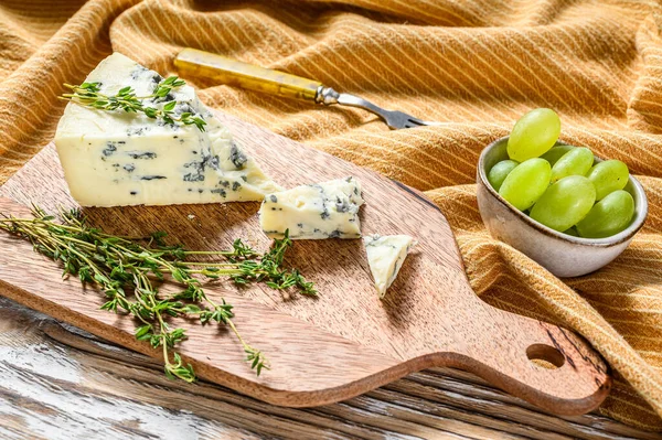 Queijo gorgonzola azul em uma tábua de corte de madeira com