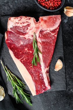 Çiğ et, biftek, baharat, sarımsak ve biberiye. Organik kemik eti. Siyah arka plan. Üst görünüm