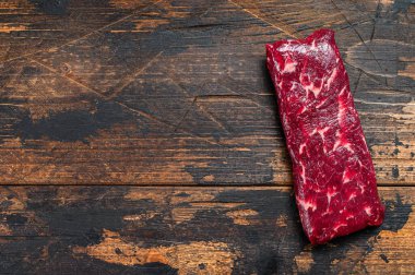 Çiğ pala ya da biftek. Koyu ahşap arka plan. Üst Manzara. Boşluğu kopyala