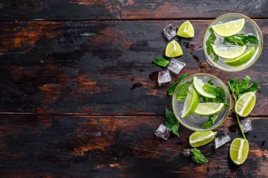 Taze limonata mojito. Naneli mojito, limon ve buz. Siyah ahşap arka plan. Üst Manzara. Boşluğu kopyala.