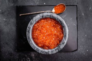 Enfes somon yumurtası, canlı ve zengin, mutfak icatlarına biraz zarafet katmak için ideal. Siyah arka plan. en üstteki görünüm.