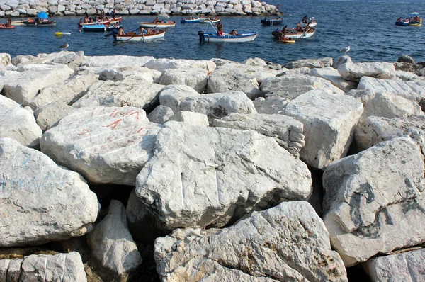 Witte steen strand en vakantiegangers op boten — Stockfoto