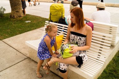 Split, Dalmaçya, Hırvatistan; 09/07/2018: Anne ve kızı rıhtımda bir bankta oturuyor.