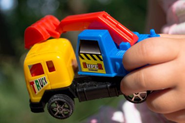 Oyuncak oyuncak araba doğa yakın çekim. Çocuk bir oyuncak tutar.