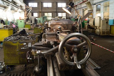 Metal atölyesi, metal işleme makineleri. Makinenin kontrol kolları. Atölyeye kurulmuş ekipman, kapatma yönetim araçları.