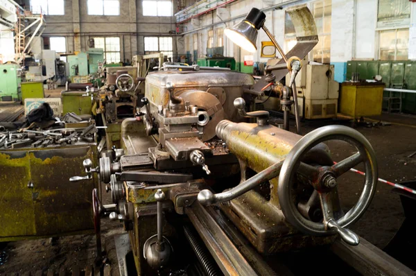 Metal atölyesi, metal işleme makineleri. Makinenin kontrol kolları. Atölyeye kurulmuş ekipman, kapatma yönetim araçları.