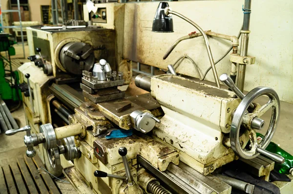 Metal atölyesi, metal işleme makineleri. Makinenin kontrol kolları. Atölyeye kurulmuş ekipman, kapatma yönetim araçları.
