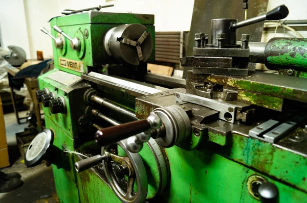 Metal atölyesi, metal işleme makineleri. Makinenin kontrol kolları. Atölyeye kurulmuş ekipman, kapatma yönetim araçları.