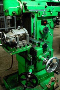 Metal atölyesi, metal işleme makineleri. Makinenin kontrol kolları. Atölyeye kurulmuş ekipman, kapatma yönetim araçları.