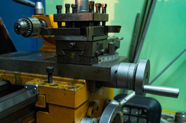 Metal atölyesi, metal işleme makineleri. Makinenin kontrol kolları. Atölyeye kurulmuş ekipman, kapatma yönetim araçları.