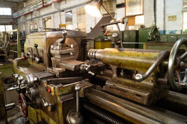 Metal atölyesi, metal işleme makineleri. Makinenin kontrol kolları. Atölyeye kurulmuş ekipman, kapatma yönetim araçları.