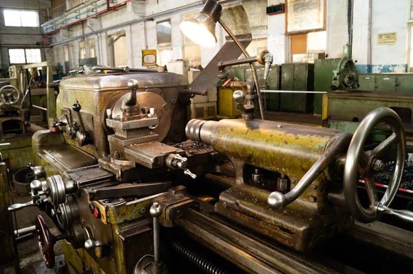Metal atölyesi, metal işleme makineleri. Makinenin kontrol kolları. Atölyeye kurulmuş ekipman, kapatma yönetim araçları.